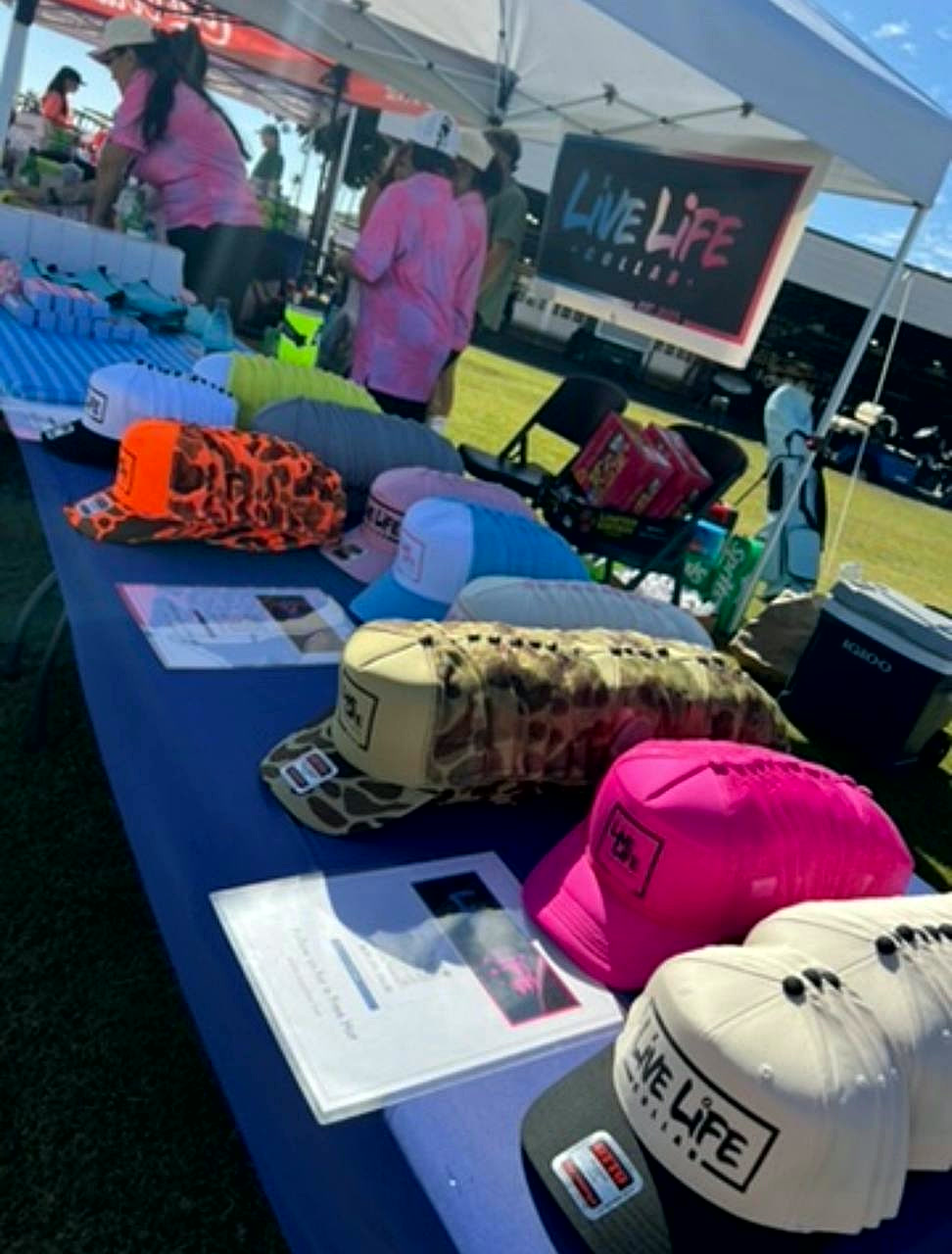 The hat range laid out on the Live Life Collab table at a market
